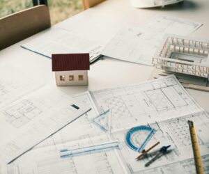 Close up model house on table and blueprint in the office room.